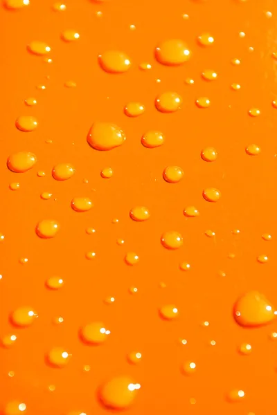 Water drops on orange metal background