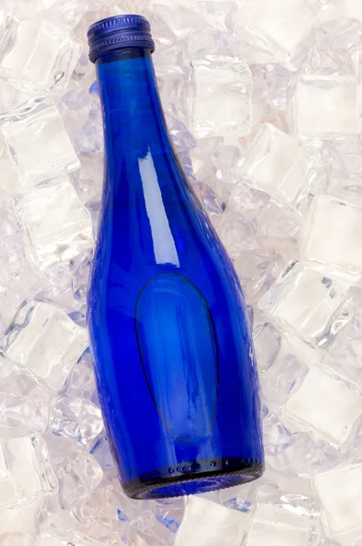 Blue bottle of water on ice cubes