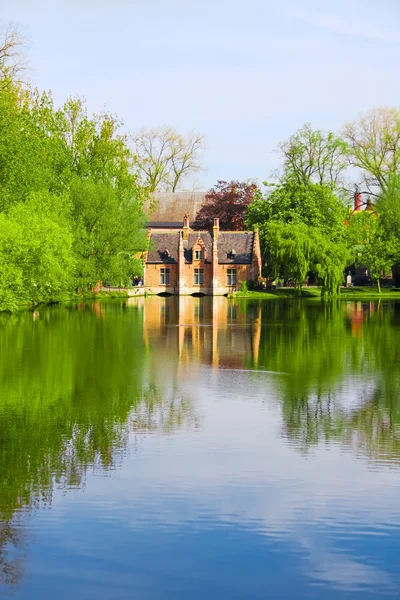 Old brick house on water in park