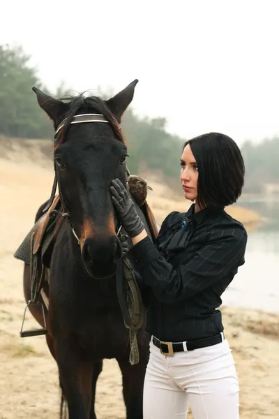 Beautiful woman with a horse near river