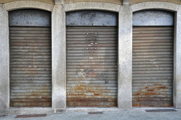 Lowered rolling shutters disused shop