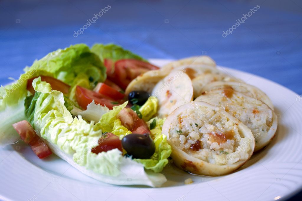 Squid stuffed with rice and greek salad - Stock Image