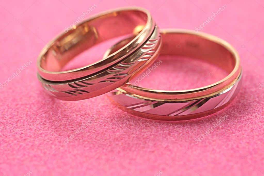 Wedding gold rings on pink background