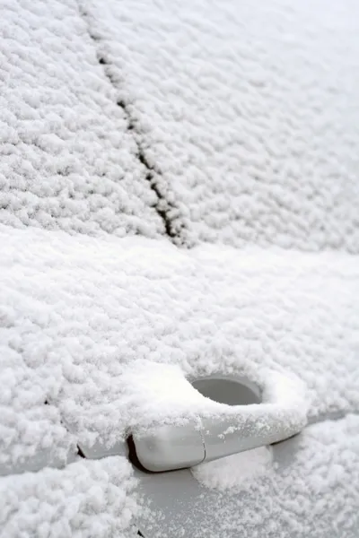Close-up of snow-covered car doors