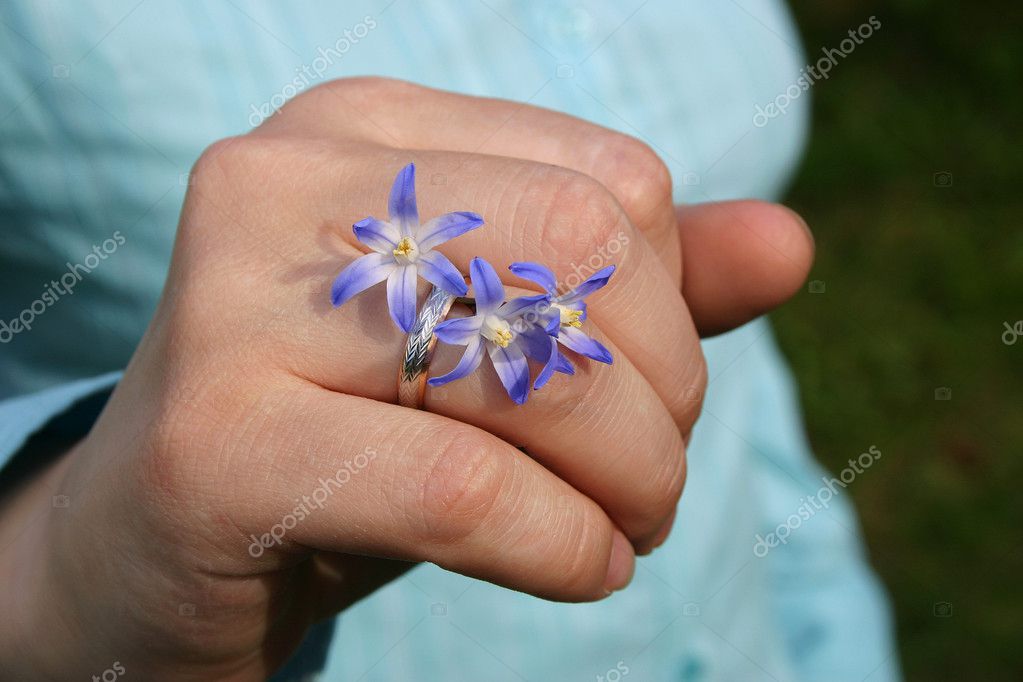 Wedding ring with flowers a primrose on a hand of the girl