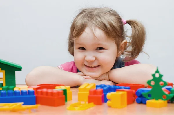 The little girl plays plastic blocks