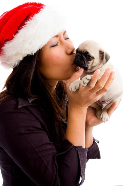 Female with christmas hat kissing puppy