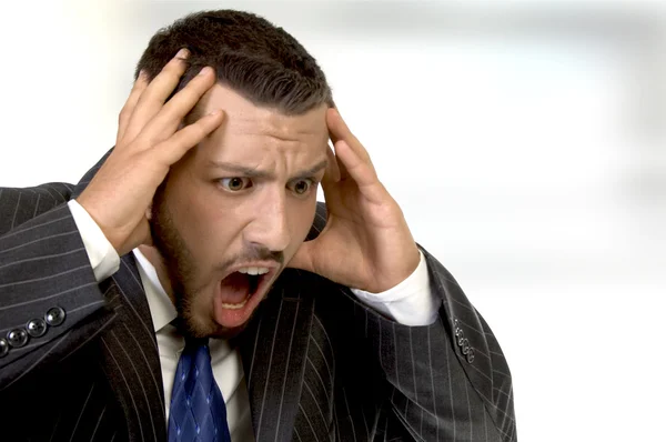 Shouting businessman holding his head