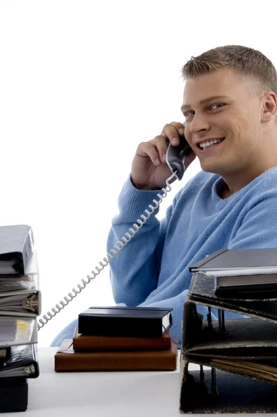 Young man talking on phone in office