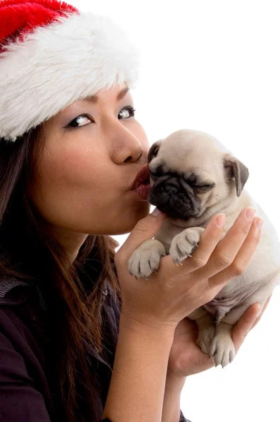 Gorgeous young female kissing puppy