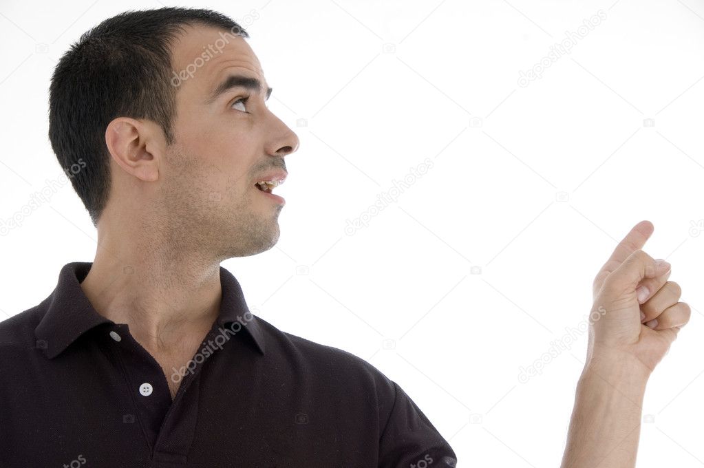 Smart pose of young guy pointing against white background