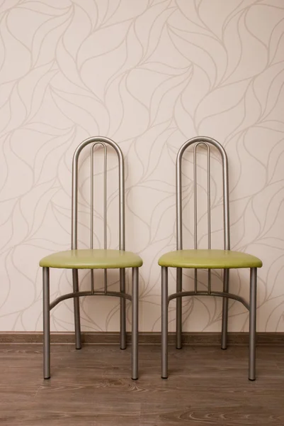 Two chairs against a beige wall