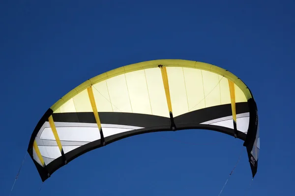 Kiteboarding yellow kite in blue sky