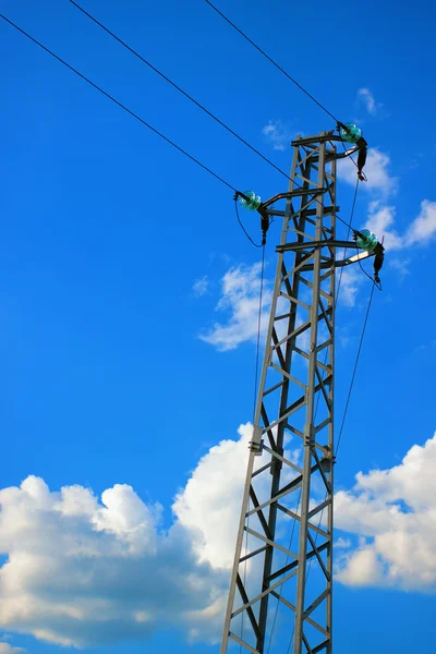 A tall electric pillar in the blue sky