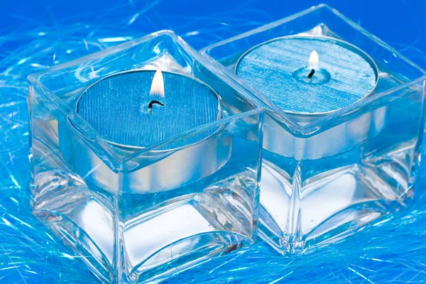 Blue candles in glass with water