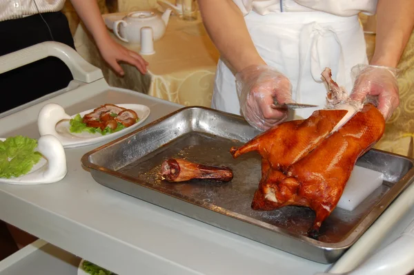A chef is cutting beijing duck