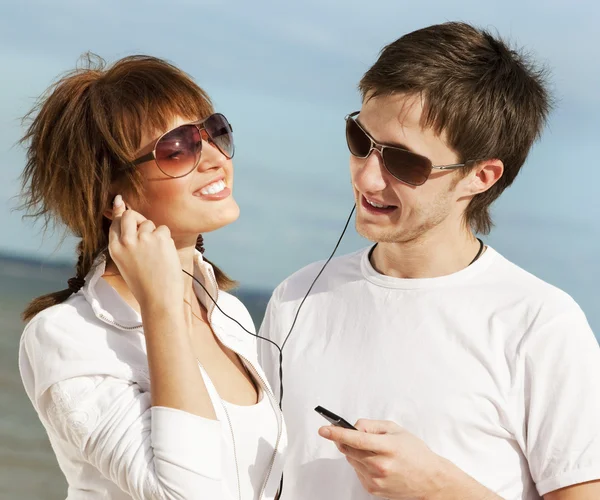 Happy young couple listening to music