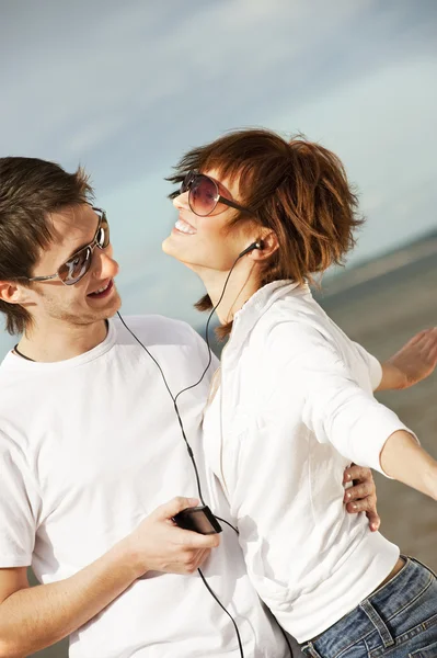 Happy young couple listening to music