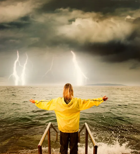 Brave woman greeting stormy ocean