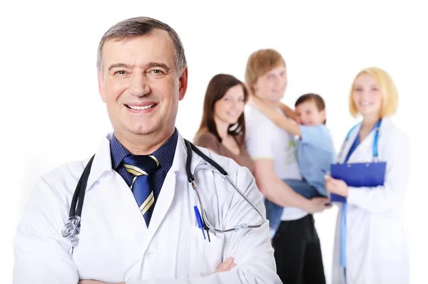 Mature doctor and young happy family by Vitaly Valua Stock Photo