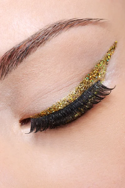 Eye make-up with golden arrow