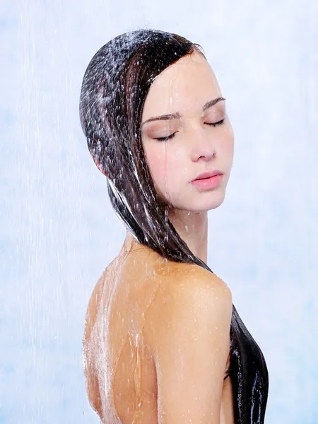 Beautiful woman taking a shower by Vitaly Valua Stock Photo