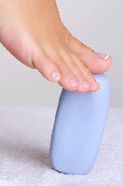 Female foot on a slice of blue soap