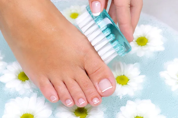 Female washes and cleans the toenails