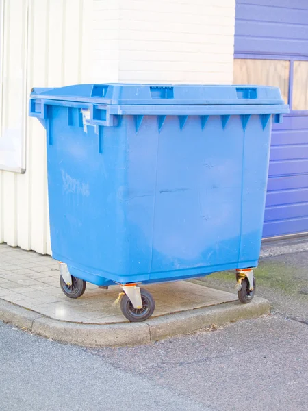 Blue plastic rubbish bin in urban area