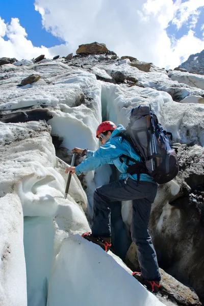 Backpacker woman with ice-axe climbing