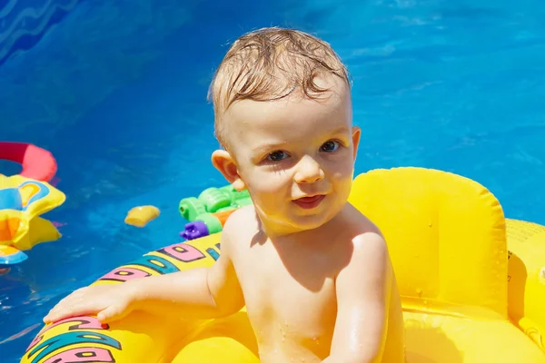 Beautiful small child swims in the pool