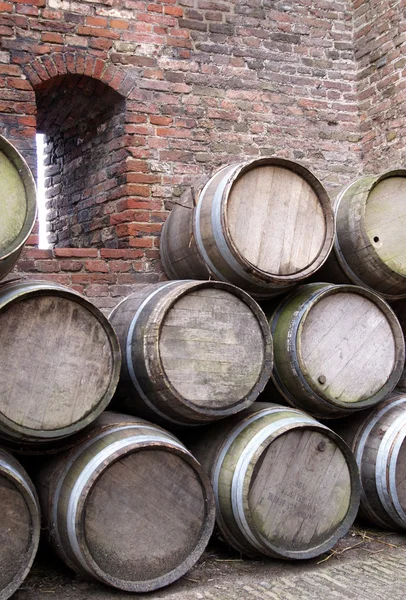 Stock of barrels against a brick wall