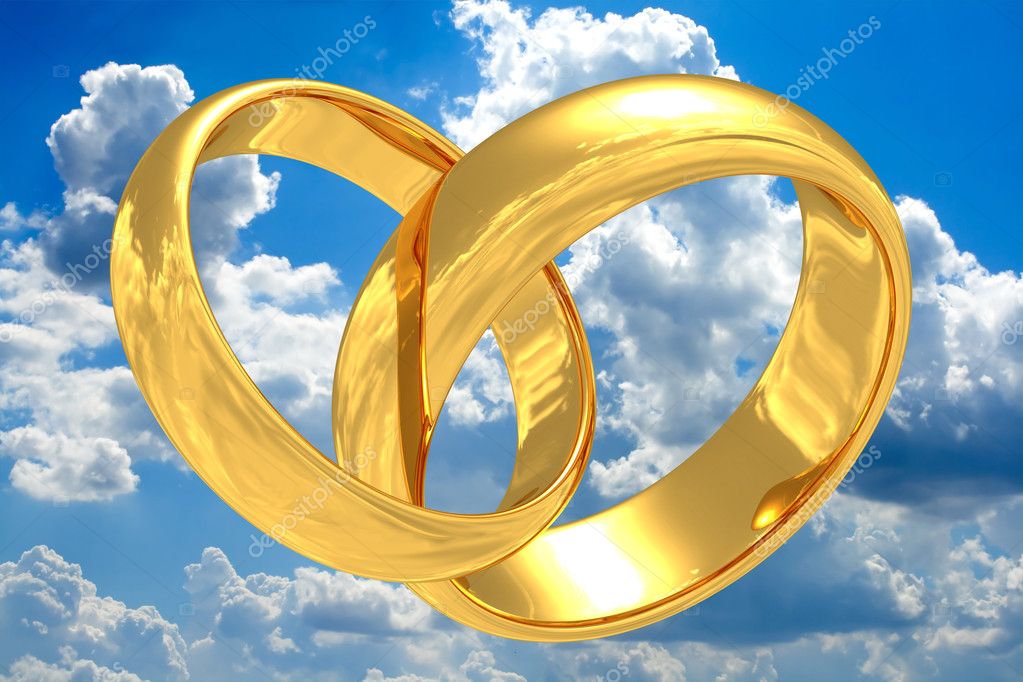 Gold wedding rings with reflection of a sky On a beautiful sky background