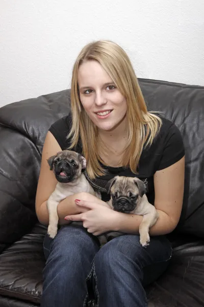 Young girl with 10 weeks old female pugs