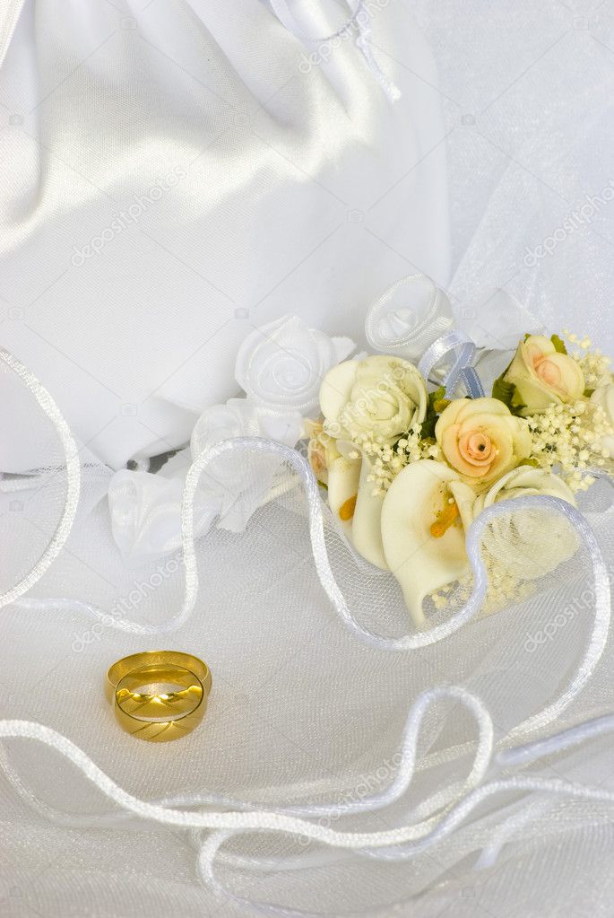 Bridal bag and wedding rings flowers decorations over bridal veil