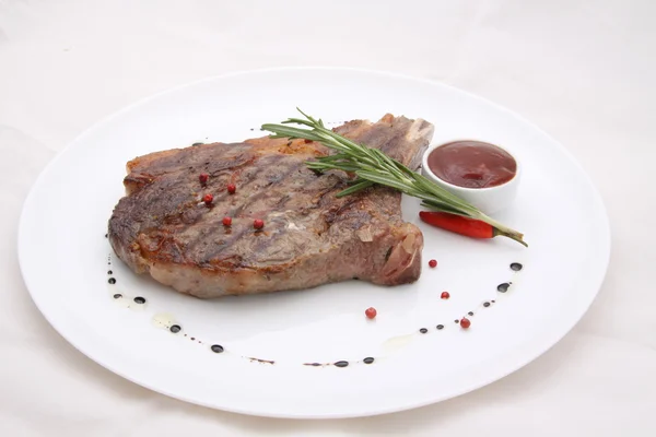 Rib-eye steak resting on a white plate