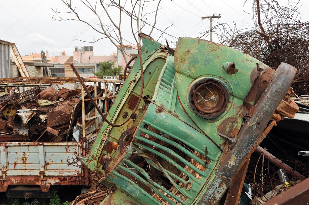 Rusty vintage car and scrap metal at a junkyard
