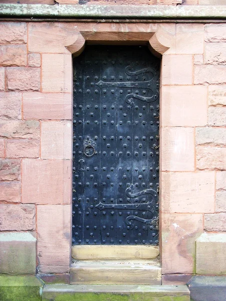 An ancient black studded door