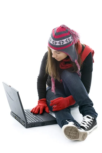 Girl in winter clothes working on laptop