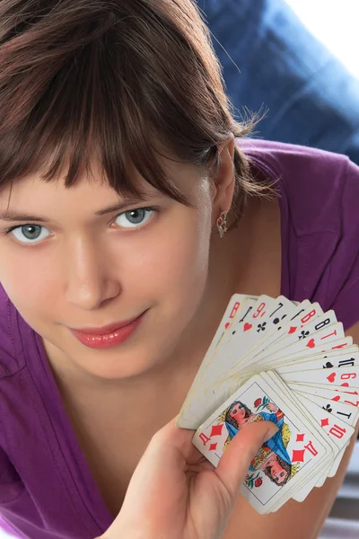 Young girl holds a pack of playing cards