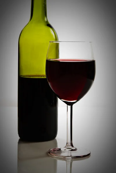 Green bottle and glass of red wine