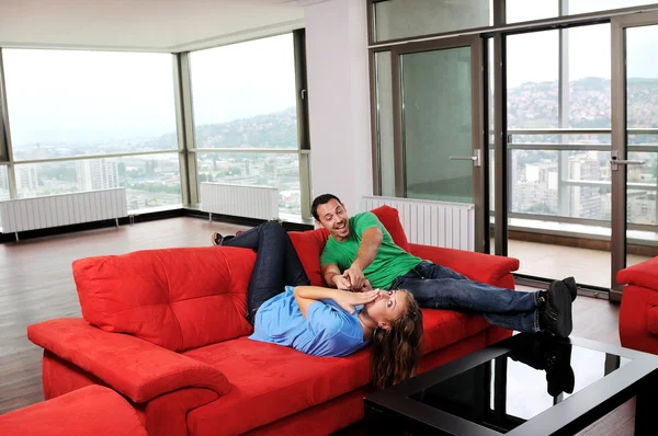 Happy couple relax on red sofa