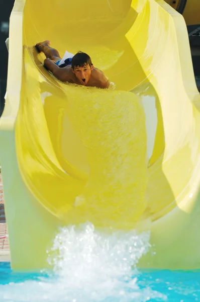 Girl have fun on water slide at outdoor swimmin