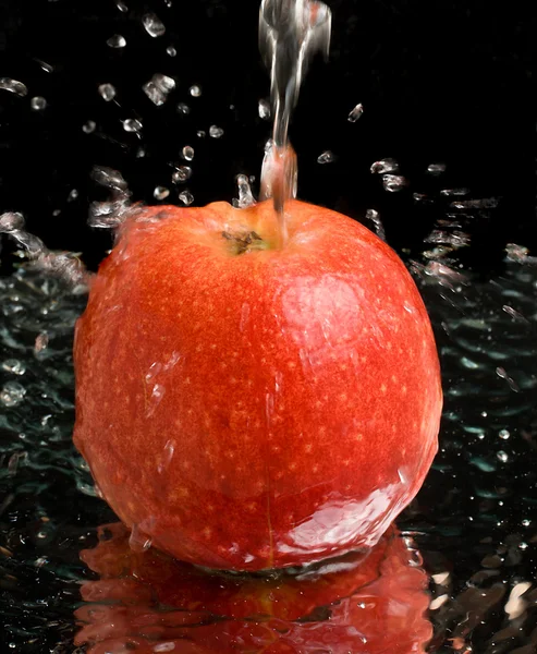 Red apple under water stream