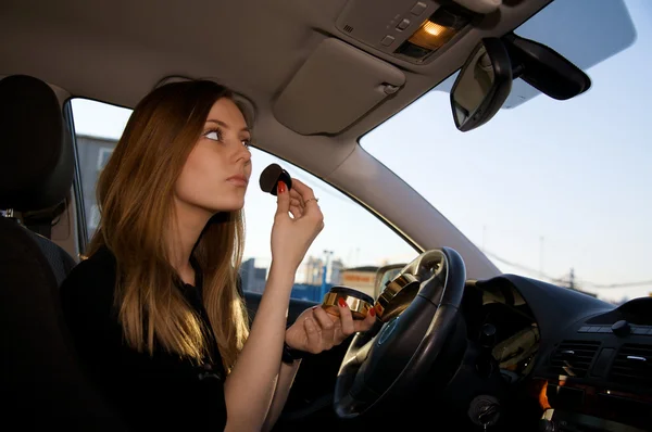 Young pretty women preparing her make-up in car