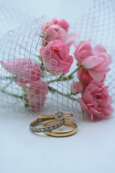 Wedding bands and pink roses