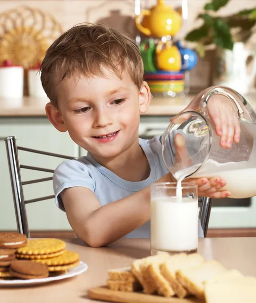Happy child pours milk from jug