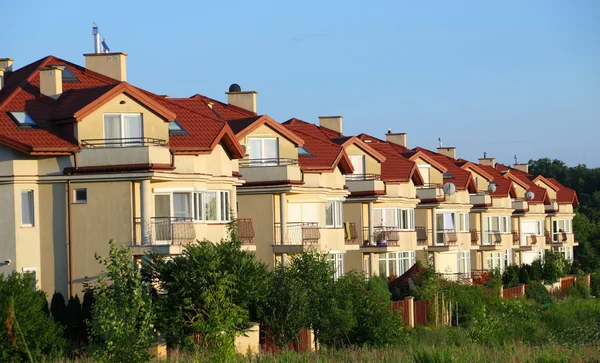 Row of similar houses over blue sky