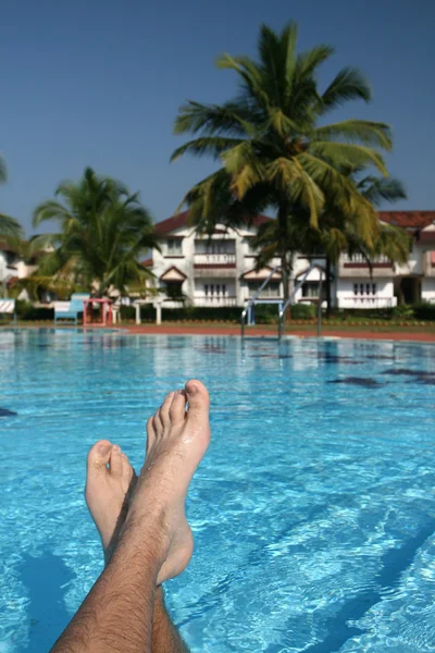 Male foots and swimming pool