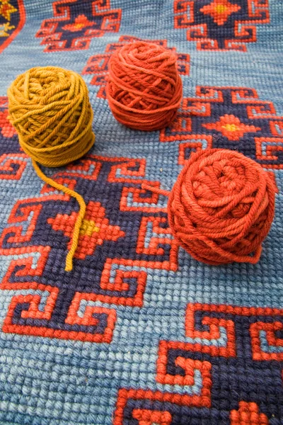 Balls of wool over knitting carpet